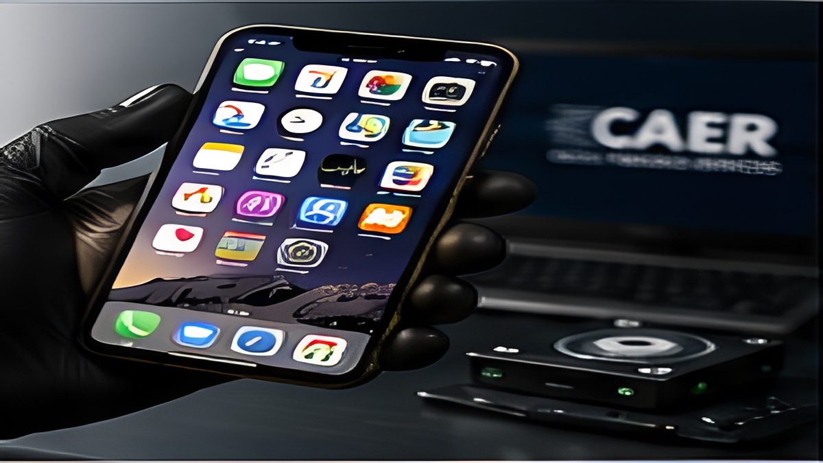 Digital forensic examiner analyzing a smartphone at a forensic workstation.